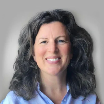 A headshot of Tina Brewer smilling